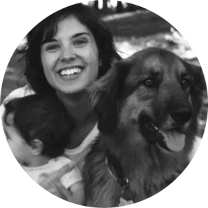 Alba Benítez sonriendo junto a su perro, un mestizo grande de pelo largo